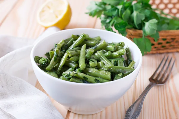 Haricots verts cuits à l'ail et au persil dans une assiette blanche — Photo