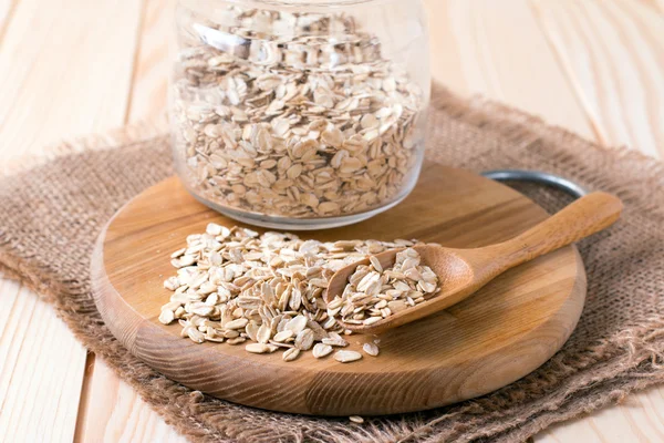 Fiocchi d'avena in cucchiaio sul tavolo di legno — Foto Stock