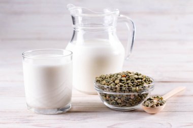 Şişedeki bezelye sütü ve beyaz tahta bir masada kavanozdaki bezelye sütü. Glütensiz, laktozsuz ürün.
