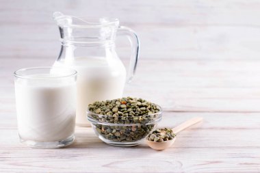 Beyaz bir masada yeşil bezelye bazlı süt. Glütensiz, laktozsuz ürün. Boşluğu kopyala.