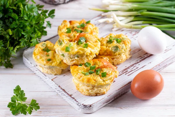 Fresh baked egg bites on a wooden board on a table