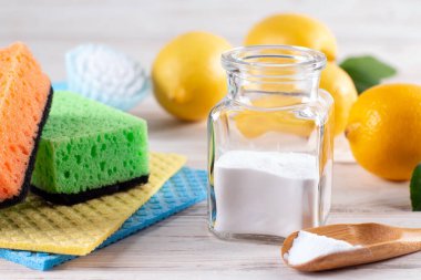 Çevre dostu doğal temizlik ürünleri: fırça, limon, kabartma tozu, beyaz arka planda kumaş. Sıfır atık yaşam tarzı