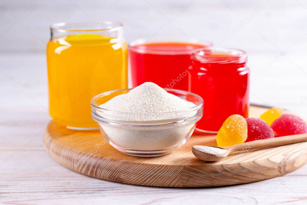 Gelling agents: gelatin, agar-agar or pectin powder with marmalade on wooden cutting board. Gelatine granules used as a gelling agent