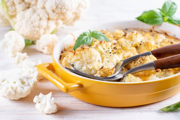 Savory food: baked cauliflower with cheese, eggs and cream close-up in a baking dish on a table. horizontal