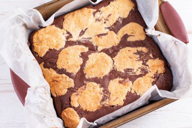 Brookiler - yarısı browni, yarısı kurabiye, yarısı kareler tarafından dilimlenmiş ahşap bir masada pişirme tepsisi içinde