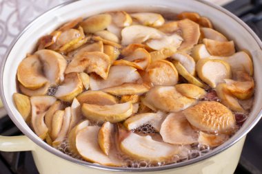 Kuru elmalar, köpüklü ve köpüklü metal bir tavada kaynar suda kaynatılır. Lezzetli ev yapımı komposto..