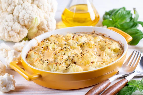 Savory food: baked cauliflower with cheese, eggs and cream close-up in a baking dish on a table. horizontal