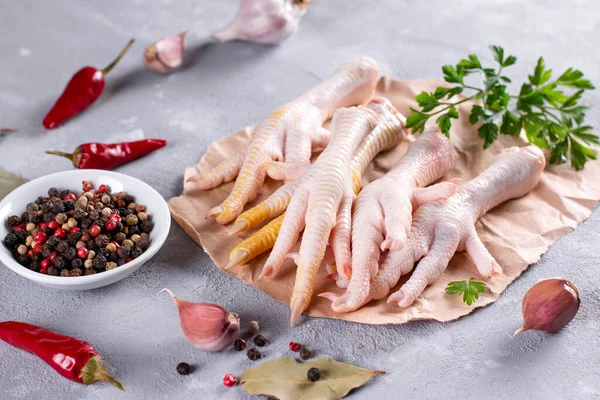Chicken feet (chicken bones ), vegetables, spices and herbs for broth on gray background. Natural collagen of animal origin