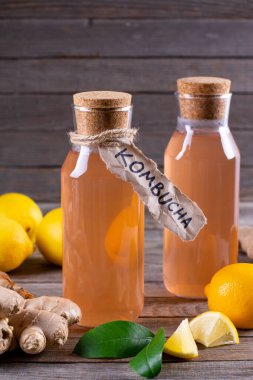 Kombucha Ginger, tahtanın üzerinde cam bardakta limon çayı. Sağlıklı içecek.