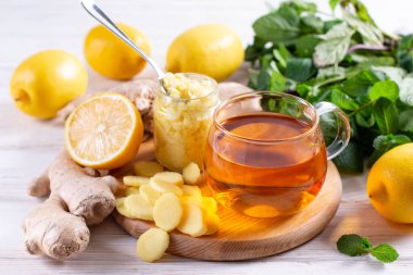 Sonbahar bağışıklık sistemi güçlendiricisi - zencefil ve limon çayı ve malzemeler, kırsal ahşap arka plan