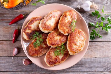 Tahta masadaki bir tabakta balık pirzolası. Üst görünüm.