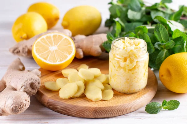 Homemade ginger and lemon jam on wooden background. Natural products to support the immune system in winter. Herbal medicine, healthy food.