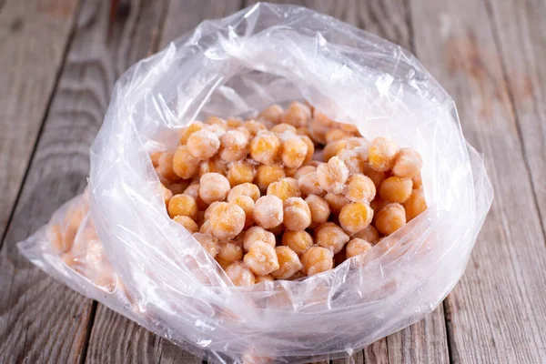 Frozen chickpeas in a bag on a wooden table