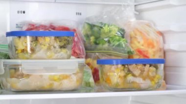 Dişi Eller buzdolabındaki cam kapları çeker. Donmuş meyveler, sebzeler, dondurucuda et.