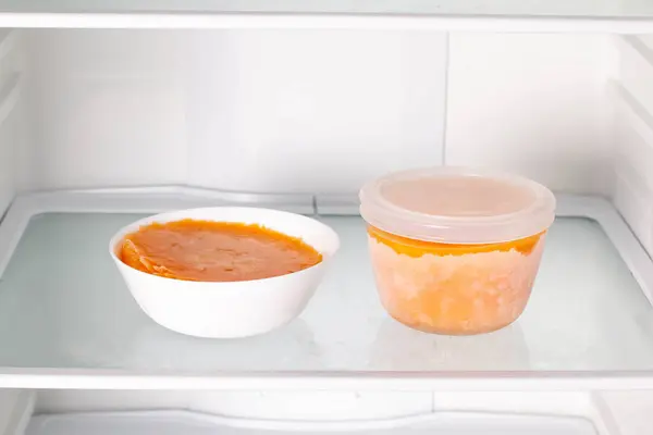 Frozen pumpkin soup in the refrigerator. Frozen food. Frozen soup. Preparing food for the week — Stock Image Frozen Pumpkin Soup Refrigerator Frozen Food Frozen Soup Preparing Food Stock Photo