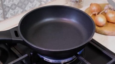 Kızartma tavasına yağ dök. Yemek pişirme süreci. Şef tavaya ayçiçeği yağı döker.