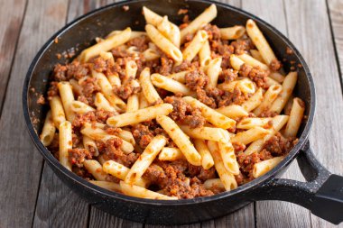 Kıymalı makarna. Ahşap arka planda geleneksel bir donanma yemeği.