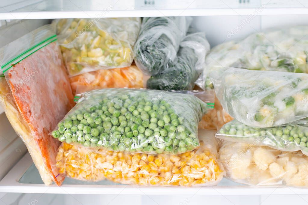 Bags with frozen vegetables in refrigerator