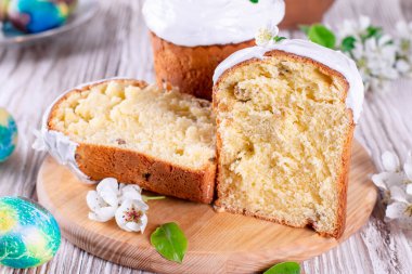 Beyaz ahşap arka planda renkli yumurtaları olan geleneksel Paskalya pastası Kulich Ukrayna usulü Rus usulü