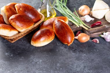 Yumurtalı ve yeşil soğanlı taze pişmiş köfteler. Koyu kahverengi masa. Geleneksel Rus ve Ukrayna ev yapımı lezzetli pirozhki. Kırsal tarzda. Boşluğu kopyala.