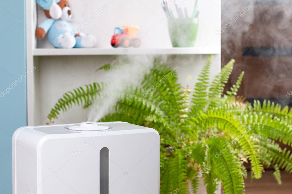 Humidifying the air in the house with a humidifier. White steam from the water. The atmosphere in the children's room.