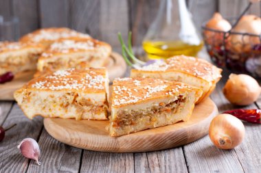 Lahana turtası. Ahşap bir tahtanın üzerinde lahana ve susam tohumlu taze ev yapımı sebze turtası.