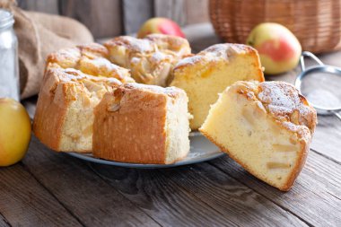 Sünger keki ya da şifon keki, malzemelerle çok yumuşak ve lezzetli: yumurta, un, ahşap masa üzerinde elma. Arkaplan ve duvar kağıdı için ev yapımı fırın kavramı.