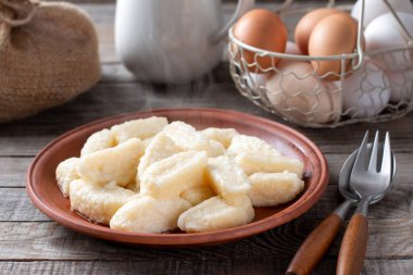 Tembel hamur tatlısı. Tabakta vareniki peyniri, ahşap arka planda kapanış.