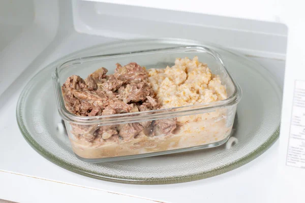 Frozen food in the freezer. Frozen meat, ready meals in a microwave oven