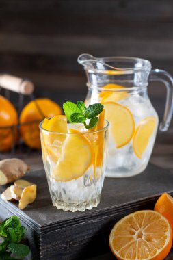 Taze limonlu limonata ve ahşap arka planda cam sürahi içinde nane.