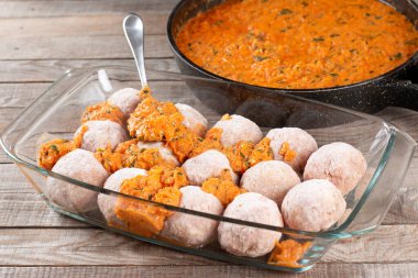 Donmuş çiğ köfteler sığır eti ve havuçlu domuz eti ve ahşap bir masada soslu pirinç.