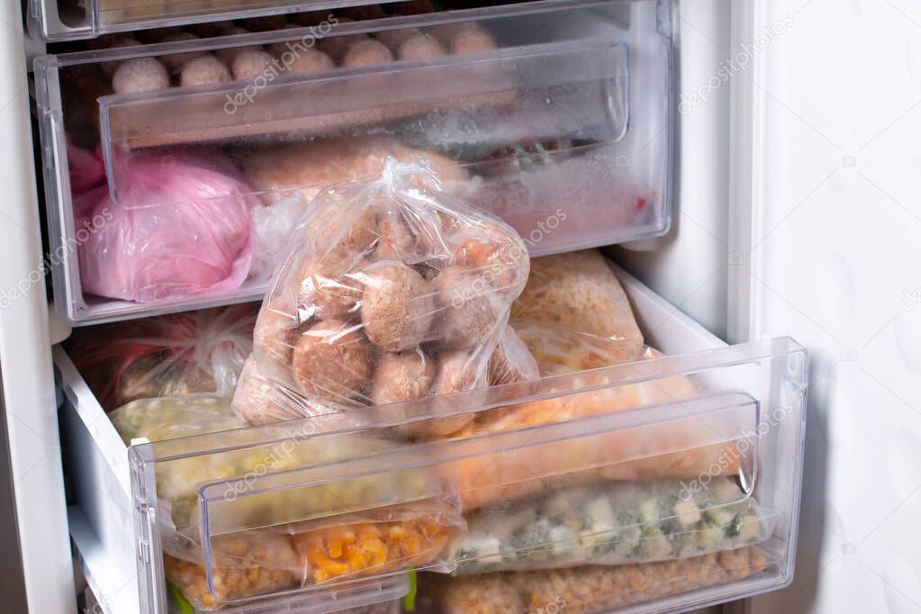 Semi-finished products, frozen meatballs, meat patties in plastic bag in refrigerator, horizontal