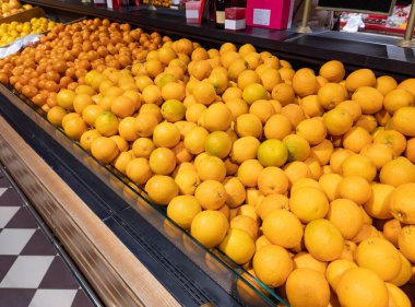 Süpermarkette bir sürü portakal. Olgun mandalina ve mandalina dolu sandıklar tezgahta satılık portakallar. Geçmişi. Seçici odak