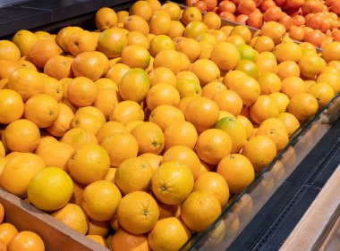 Süpermarkette bir sürü portakal. Olgun mandalina ve mandalina dolu sandıklar tezgahta satılık portakallar. Geçmişi. Seçici odak
