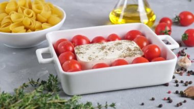 Fırında makarna pişiriyorum. Pişmeden önce ham malzemeler: makarna, feta peyniri, zeytinyağı ve sarımsaklı kiraz domatesleri. Fetapasta