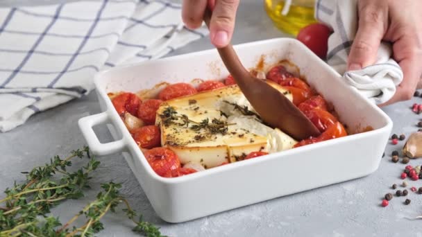 法塔芝士面酱配方步骤 点缀着橄榄油的小西红柿在烤盘里 中间放着一个奶酪块 上面撒满了盐和新鲜的辣椒 — 图库视频影像