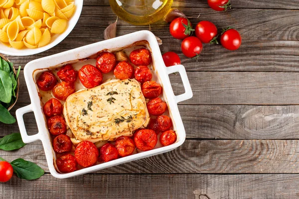 Preparation of ingredients for feta pasta. Trending Feta bake pasta recipe made of cherry tomatoes, feta cheese, garlic and herbs. Top view, above, copy space.