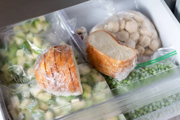 Frozen bread in the home freezer, baguette in reserve on a shelf of a home freezer, long life food storage concept.