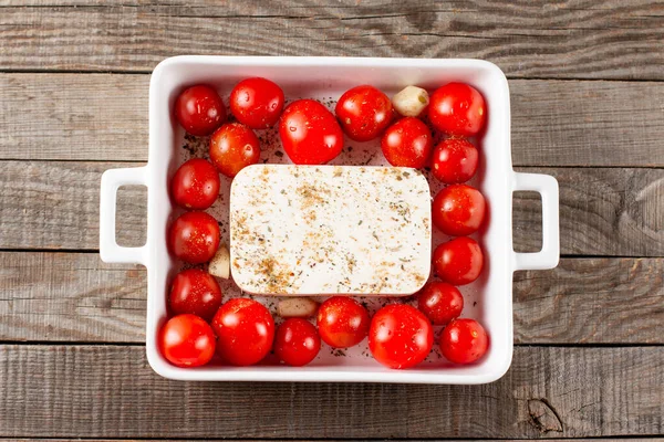 Step by step cooking instructions for the viral Feta bake pasta recipe with roasted cherry tomatoes, cheese, herbs and garlic on a wooden table. Top view, above, copy space.