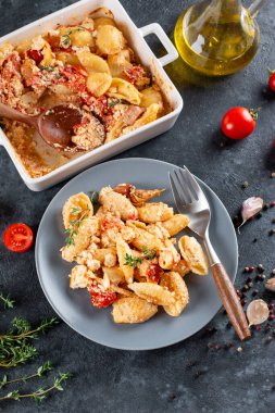 Akşam yemeği için fırında makarna malzemesi koyu arkaplanda bir tabakta. Ev yemeği konsepti.