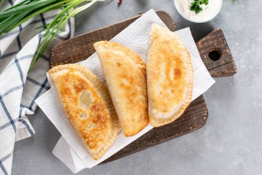 Cheburek, et ve soğanlı kızarmış turta. Pek çok Türk ve Moğol halkının geleneksel yemeği. Üst Manzara. Boşluğu kopyala.