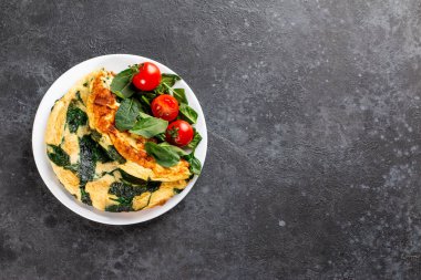 Yumurta, peynir ve ıspanak salatasından yapılmış Frittata. Frittata, gri arka planda beyaz tabakta İtalyan omleti. Ketogenic, keto food, metin için menü tarifi yeri, üst görünüm