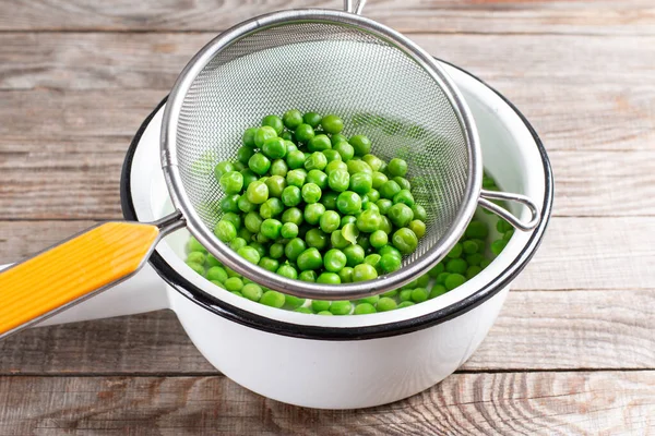 Groene Erwten Een Vergiet Gekookte Geblancheerde Groenten Een Houten Tafel — Stockfoto