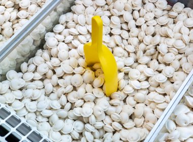 Donmuş hamur köfteleri bir tezgahın üstündeki buzdolabında ağırlıkla satılıyor. Donmuş gıda satışları