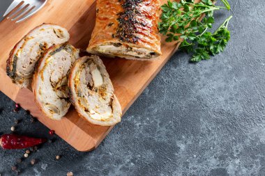 Dilimlenmiş domuz rostosunun genel manzarası Porchetta, İtalyan mutfağının leziz domuz rostosu taş bir arka planda, düz bir zeminde, fotokopi alanı.