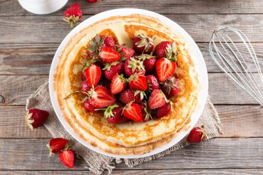 Çilekli krep, yakın plan. Maslenitsa. Çilekli taze pişmiş krep. Krep şeklinde bir tatlı. Üst görünüm.