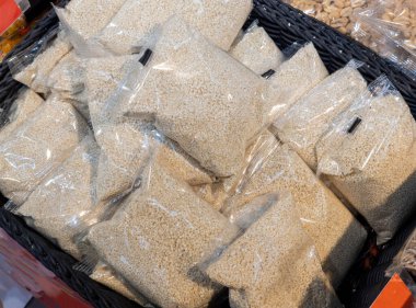 Naylon poşetlere doldurulmuş doğal susam tohumları mağazada satılıyor. Susam tohumları zaten rafta ve pazarda satılmaya hazır. Diyet, sağlıklı yemek..