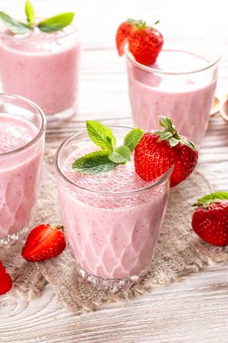 Eski ahşap arka planda taze, sağlıklı çilekli smoothie.