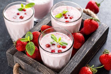Eski ahşap arka planda taze, sağlıklı çilekli smoothie.