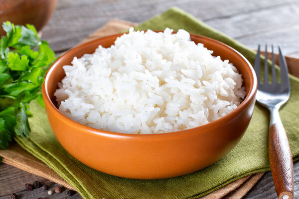 Cooked rice in a bowl on an old wooden table